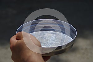Empty bowl in hand as concept of global famine and hunger crisis