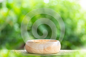 Empty bowl on wooden table with green blur light background