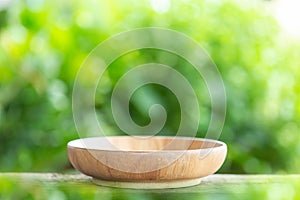 Empty bowl on wooden table with green blur light background