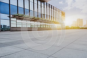 Empty brick floor with modern building in background