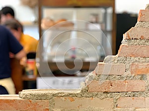 Empty bricks wall with blurred cafe background.