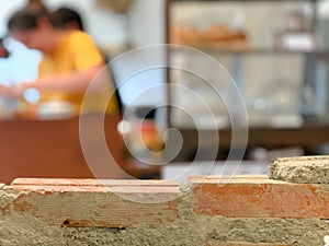 Empty bricks wall with blurred cafe background.