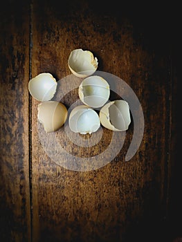 an empty broken chicken egg shell without its contents on an old wooden table