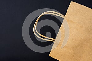 Empty Brown Craft Paper Bag on Black Background. Sales Discount Shopping. Black Friday Cyber Monday.