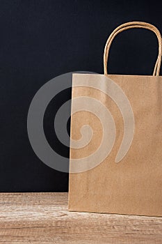 Empty Brown Craft Paper Bag on Black Background. Sales Discount Shopping. Black Friday Cyber Monday. Christmas Gifts.