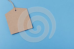 Empty brown paper tag tied with string. price tag on blue background