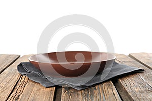 Empty brown plate and napkin on table against white background