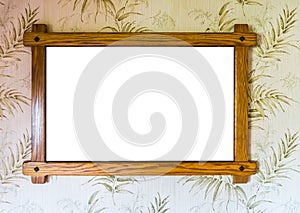 Empty brown wooden picture frame hanging on a wall with decorated wallpaper background