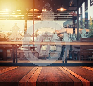 Empty brown wooden table surface and coffee shop blur background with bokeh image