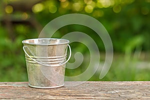 Empty bucket on the board on a background of green