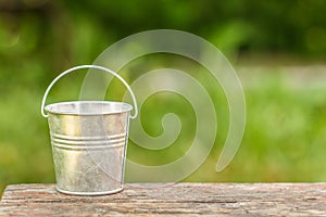 Empty bucket on the board on a background of green