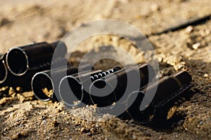 An empty bullet belt of a bullet lies on the sand, a bullet in the sand