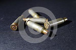 Empty bullet shell casings, on a black background, smoke