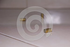 Empty bullet shells on the house floor. Bullet casings on the ceramic floor. selective focus