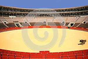 Empty bullring in Spain with contrast colors of red ring and blue sky