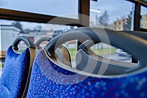 Empty bus interior with blue patterned seats and window view