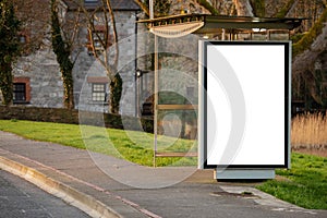 Empty bus stop in town with blank mock up vertical billboard for advertising