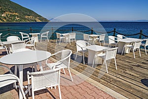 Empty cafe with chairs and tables by the seafront under a blue sky in summer