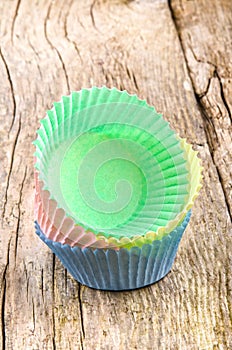 Empty cake paper cases on a timber board