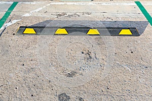 Empty car park lot with black-yellow rubber Wheel Stopper. Parking lot is divided for making a slot for the park each car by a whi