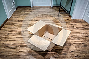 Empty cardboard box on tilled floor