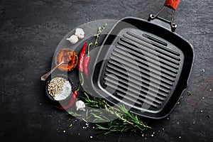 Empty cast-iron grill pan with ingredients for cooking on black background