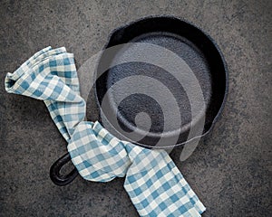 Empty cast iron skillet frying pan flat lay on dark stone background with copy space .