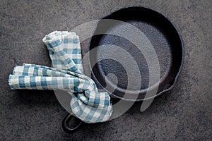 Empty cast iron skillet frying pan flat lay on dark stone background with copy space .