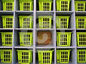 Empty cell among filled cells with plastic storage boxes at storage room