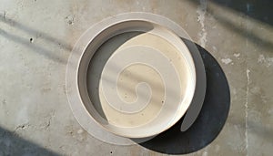 Empty ceramic dish plate on textured surface. Rustic tableware, minimalism, kitchen design, home decor. Top view of dish, food