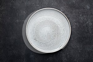 Empty ceramic plate isolated on black stone background