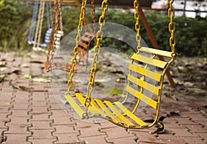 Empty chain swings in playground with vintage filter
