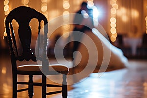 empty chair by the dance floor with wedding couple blurred behind