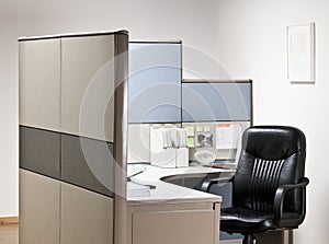 Empty chair at desk in cubicle