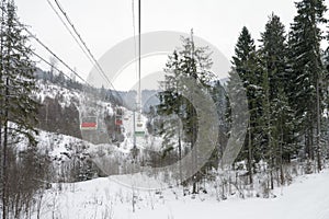 Empty chair ski lift on the gloomy mountains. Winter time.