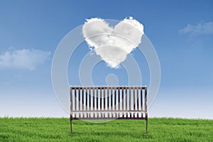 Empty chair under heart clouds