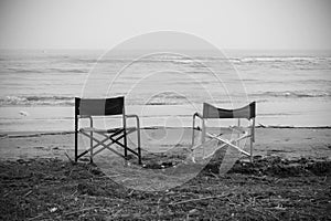 Empty chairs in front of sea