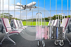 Empty chairs in the hall of airport terminal with the luggage on cart and an airplane taking off Travel and transportation concept