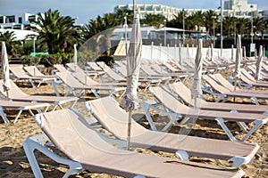 Empty chaise-lounges on the beach in the city of Costa Teguise