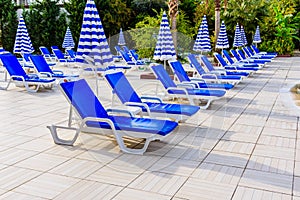 Empty chaise lounges and sun umbrellas near the swimming pool