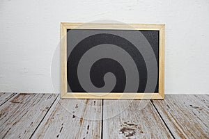 Empty chalkboard easel on wooden shelves background