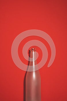 Empty champagne bottle on red background