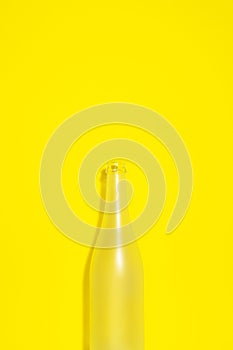 Empty champagne bottle on yellow background