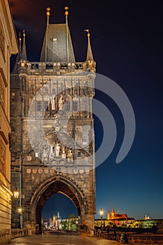 Empty Charles Bridge in the center of Prague during first wave of Covid-19 pandemy in the night with blue sky and yello