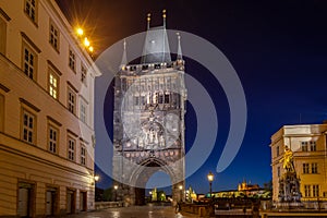 Empty Charles Bridge in the center of Prague during first wave of Covid-19 pandemy in the night with blue sky and yello