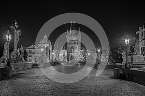 Empty Charles Bridge in the center of Prague during first wave of Covid-19 pandemy in the night with blue sky and yello