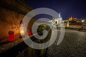 Empty Charles Bridge in the center of Prague during first wave of Covid-19 pandemy in the night with blue sky and yello