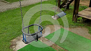 Empty children`s swings on a chain swinging