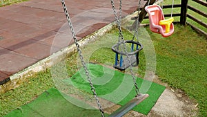 Empty children`s swings on a chain swinging