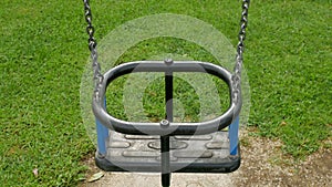Empty children`s swings on a chain swinging